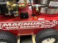 A 2024 Magnum 4000 Hot Water Pressure Washer with a red body featuring the label Magnum 4000 Series Gold and equipped with high-pressure hoses and wheels for mobility