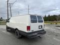 A white 2001 Ford Econoline van parked with a plain rear view featuring black tires and a license plate visible on the back