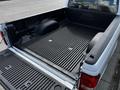 The image shows the open bed of a 2010 Ford Ranger featuring a textured rubber liner and the Ford logo embossed on the tailgate