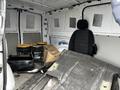 The interior of a 2018 Mercedes-Benz Metris van featuring buckets, a box, and a driver's seat amidst scattered materials