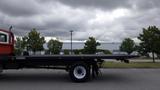 A 2015 International DuraStar 4300 flatbed truck parked with a long flatbed and a red cab visible on the left side