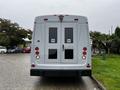 A 2015 Chevrolet Express with a gray exterior and double rear doors featuring circular logos on each door