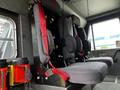 Interior of a 2002 Sutphen Monarch showing two black seats with red seatbelts designed for firefighter use