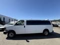 A white 2007 Chevrolet Express van with no visible logos and tinted windows parked in a lot with other vehicles in the background
