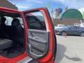A red 2012 RAM 2500 truck with the driver's side door open showing the interior seating and door panel details