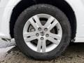 Close-up of a silver alloy wheel of a 2017 Dodge Grand Caravan with a black tire showcasing five spokes and a prominent center hub