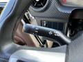 Close-up of the steering column controls of a 2021 Hino 338 featuring light switches and wiper controls with a textured black finish
