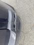 A close-up of the front bumper of a 2009 BMW X5 showing damage with a crack and scuff marks on the black plastic surface