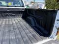 A 2016 GMC Sierra 1500 truck bed showing a textured black lining and the GMC logo embossed on the side