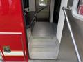 Inside a 2007 Ford F-550 with a red exterior featuring metal diamond plate steps leading up to a black seating area and handrails on the side
