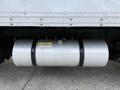 A shiny silver fuel tank mounted on the underside of a vehicle with a black strap securing it in place