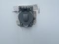 A gray electrical outlet cover mounted on a wall with visible adhesive and peeling material around it