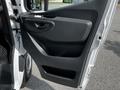 The interior door panel of a 2020 Mercedes-Benz Sprinter featuring a black handle and sleek design elements