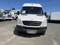 A 2010 Mercedes-Benz Sprinter with a white exterior and a black front grille positioned in the foreground facing directly towards the viewer