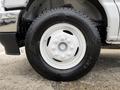 Close-up of a white wheel and tire of a 2022 Ford E-450 featuring a six-bolt pattern and all-season tread designed for durability and performance