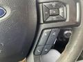 Close-up of the steering wheel controls of a 2016 Ford F-150 including buttons for volume calling and menu navigation
