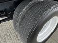 Close-up of the rear dual tires of a 2022 Isuzu NPR showing tread pattern and shiny silver rim