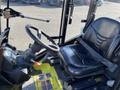 Interior of a 2010 Kubota F3990 featuring a steering wheel and a black driver seat with a seat belt and control panel with gauges and levers