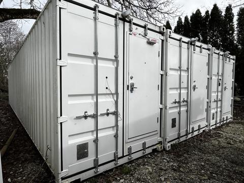 A white 40-foot custom climate-controlled storage container with multiple doors and metal latches