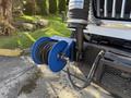 A blue hose reel with black hose attached to a 2013 International 7400 truck