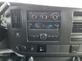 Dashboard of a 2015 Chevrolet Express featuring air conditioning controls radio display and various buttons for vehicle functions