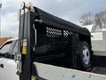 A 2021 Ford F-550 with a black dump truck bed featuring a mesh cover and a spare tire mounted on the side