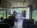 Interior of a 2005 Workhorse Glaval LF72 21 Passenger Bus showing seats and driver area with two passengers seated in the middle and front