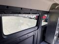 A 2021 RAM Promaster interior featuring a large window with a metal framework and a metallic structure on the right side
