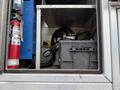 A 2015 Ford F-350 SD with a visible battery compartment containing a large battery and various cables