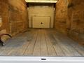 Empty cargo space of a 2018 Ford Econoline with wooden flooring and interior walls made of plywood