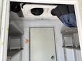 Interior view of a 2019 Freightliner MT45 with metal shelves on both sides and a ceiling-mounted cooling unit above