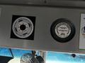 A 2012 Ford Econoline dashboard displaying two circular stickers with informational text and diagrams about vehicle maintenance and alignment