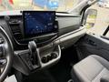 The interior of a 2022 Ford Transit featuring a touchscreen display gear shift and driver seat