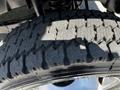 Close-up of a large truck tire showing deep tread patterns and grooves typical of a 2008 Ford F-550 tire designed for heavy-duty performance