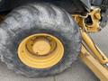 Close-up of a large yellow wheel with deep treads belonging to a 2012 John Deere 310SJ heavy equipment vehicle