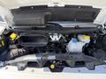 An open hood of a 2021 RAM Promaster revealing the engine compartment with various components including coolant reservoir and air intake system