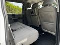 Interior view of a 2020 Ford F-350 Super Duty with gray upholstered rear seats folded up for additional space