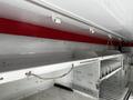 A 2013 Ford Econoline featuring overhead storage shelves and a red stripe along the top with white interior walls and various organizing compartments visible