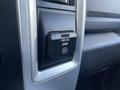 A close-up view of an AC power outlet with a label indicating 115V and 150W in a 2011 RAM 1500 vehicle