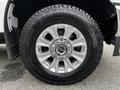 A close-up of a silver alloy wheel on a 2020 Ford F-350 SD with a large tire showcasing a deep tread pattern
