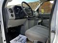 Interior of a 2019 Ford Econoline showing the driver's seat dashboard and controls with a floor mat that says thank you