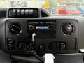 Interior dashboard of a 2014 Ford Econoline featuring a radio control unit several switches and knobs for climate control and other functions