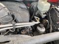 Close-up of a 2012 RAM 2500 engine showing various components including the air intake the radiator reservoir and several hoses and cables