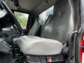 Interior view of a 2011 International 4400 showing the driver's seat and controls with a focus on the gray upholstery and seating arrangement