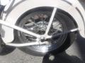 A close-up view of the rear wheel of a 1947 Harley-Davidson WL showcasing its chrome spokes and black tire