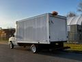 A white 2017 Ford Econoline cargo van with a large enclosed box in the back and a roof light on top