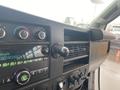 The interior dashboard of a 2017 Chevrolet Express featuring climate controls audio system and various knobs and buttons