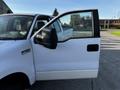 A white 2008 Ford F-150 XL with the driver's door open showing the interior and side mirror