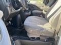 Interior view of a 2012 GMC Savana showing two front seats with gray upholstery and a black floor mat