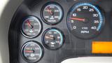 Close-up of a vehicle's dashboard with gauges displaying engine oil, water temperature, tire pressure, and transmission temperature along with a digital RPM display